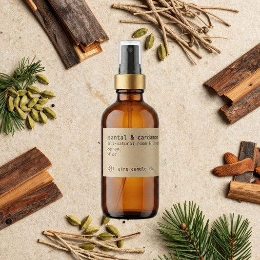 Aire Candle Co. Santal & Cardamom Essential Oil Scented Room Spray Surrounded by Scent Notes of Sandalwood, Cedarwood, Cardamom, Cypress, Pine Needles and Vetiver Essential Oils.