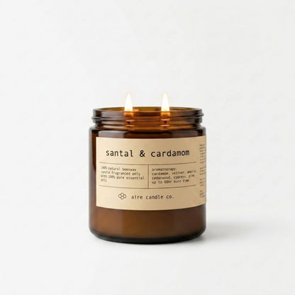 Santal & cardamom candle in an amber jar with a label on a white background