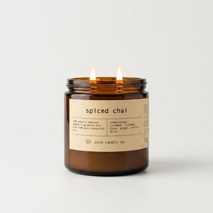 Spiced chai candle in a glass jar with a label on a light gray background