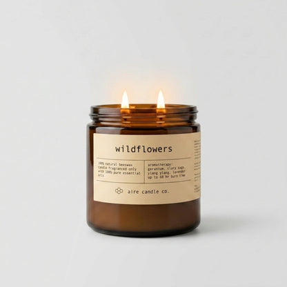 Wildflowers candle in an amber jar with a label on a white background