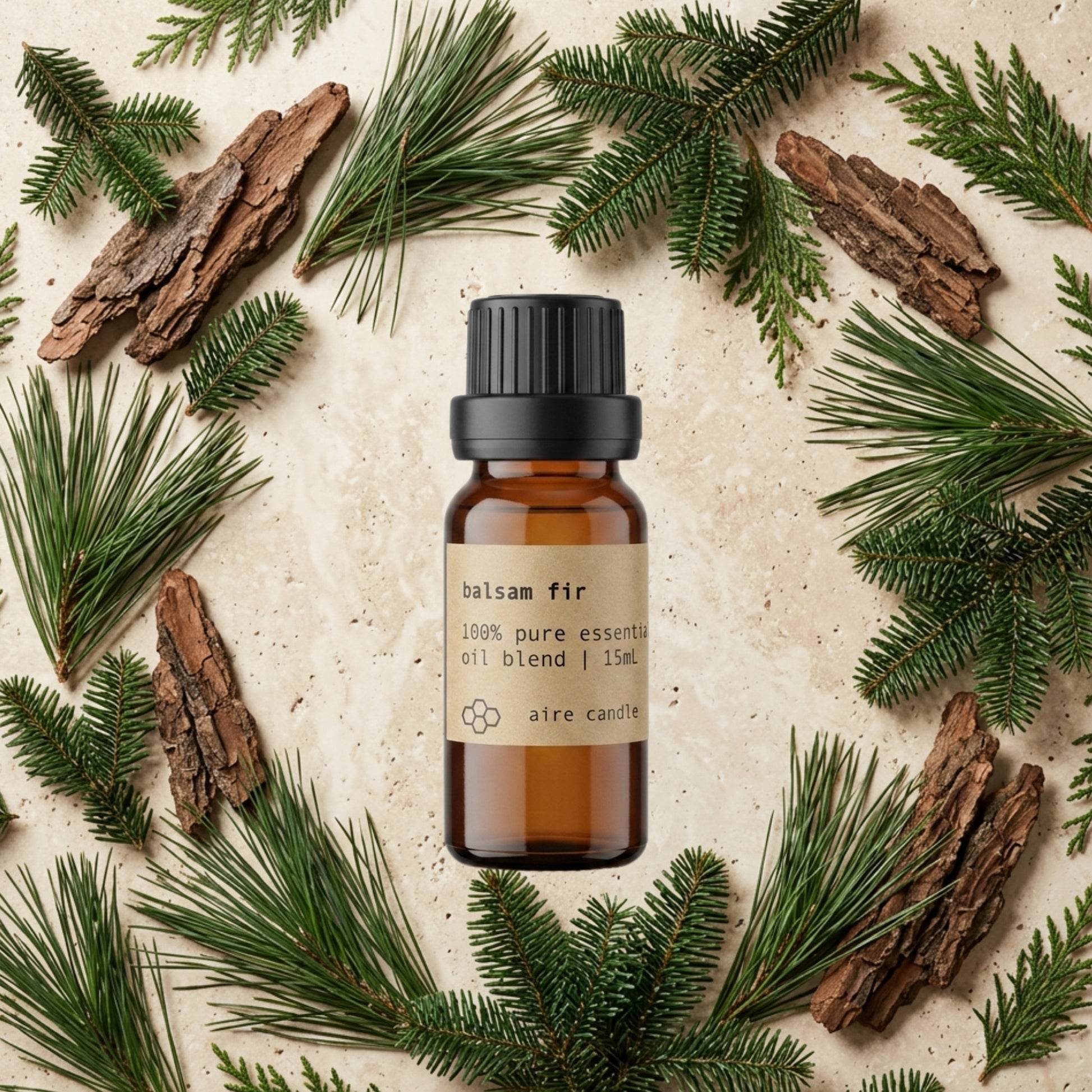 Bottle of Aire Candle Co. Balsam Fir Essential Oil Blend Surrounded by Scent Notes of Fir Needle, Cedar Bark, Pine Needles and Cypress Essential Oils on a Travertine Surface.