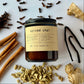 Spiced chai candle with spices and herbs on a white background