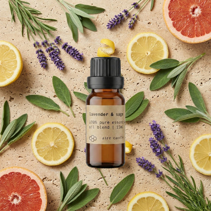 Bottle of Aire Candle Co. Lavender & Sage Essential Oil Blend Surrounded by Scent Notes of Lavender, Sage, Lemon and Grapefruit Essential Oils on a Travertine Surface.