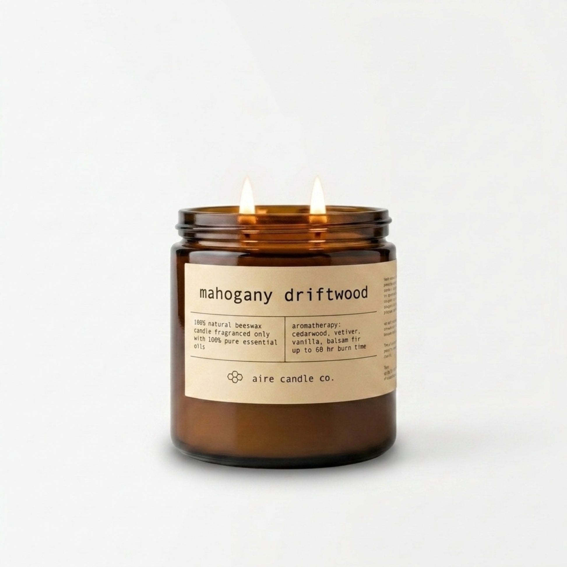 Mahogany Driftwood beeswax candle in a 16 oz amber jar with a label on a white background