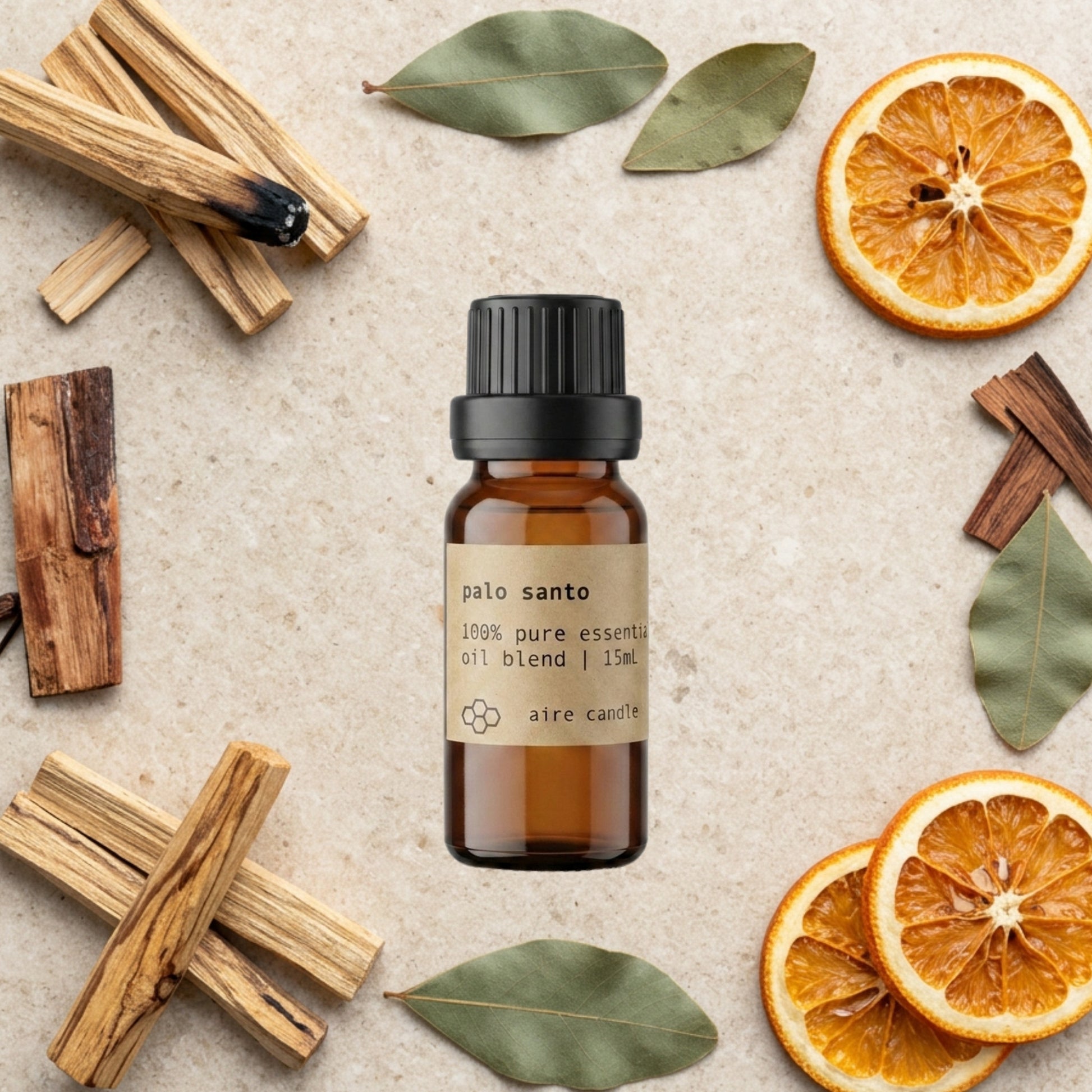 Bottle of Aire Candle Co. Palo Santo Essential Oil Blend Surrounded by Scent Notes of Palo Santo, Cedarwood, Patchouli and Orange Essential Oils on a Travertine Surface.
