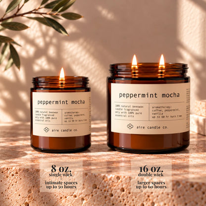 8 oz aire candle displayed next to the 16 oz beeswax candle. The 8 oz has a single wick and is intended for intimate spaces. It burns up to 50 hours. The 16 oz candle has two wicks and is intended for larger spaces. It burns up to 60 hours.