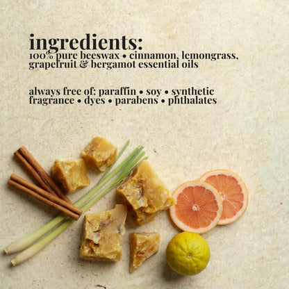Text listing ingredients for a beeswax wax melt pack on a light stone background, with pieces of beeswax, cinnamon sticks, lemongrass, grapefruit slices and a bergamot shown as supporting visuals.