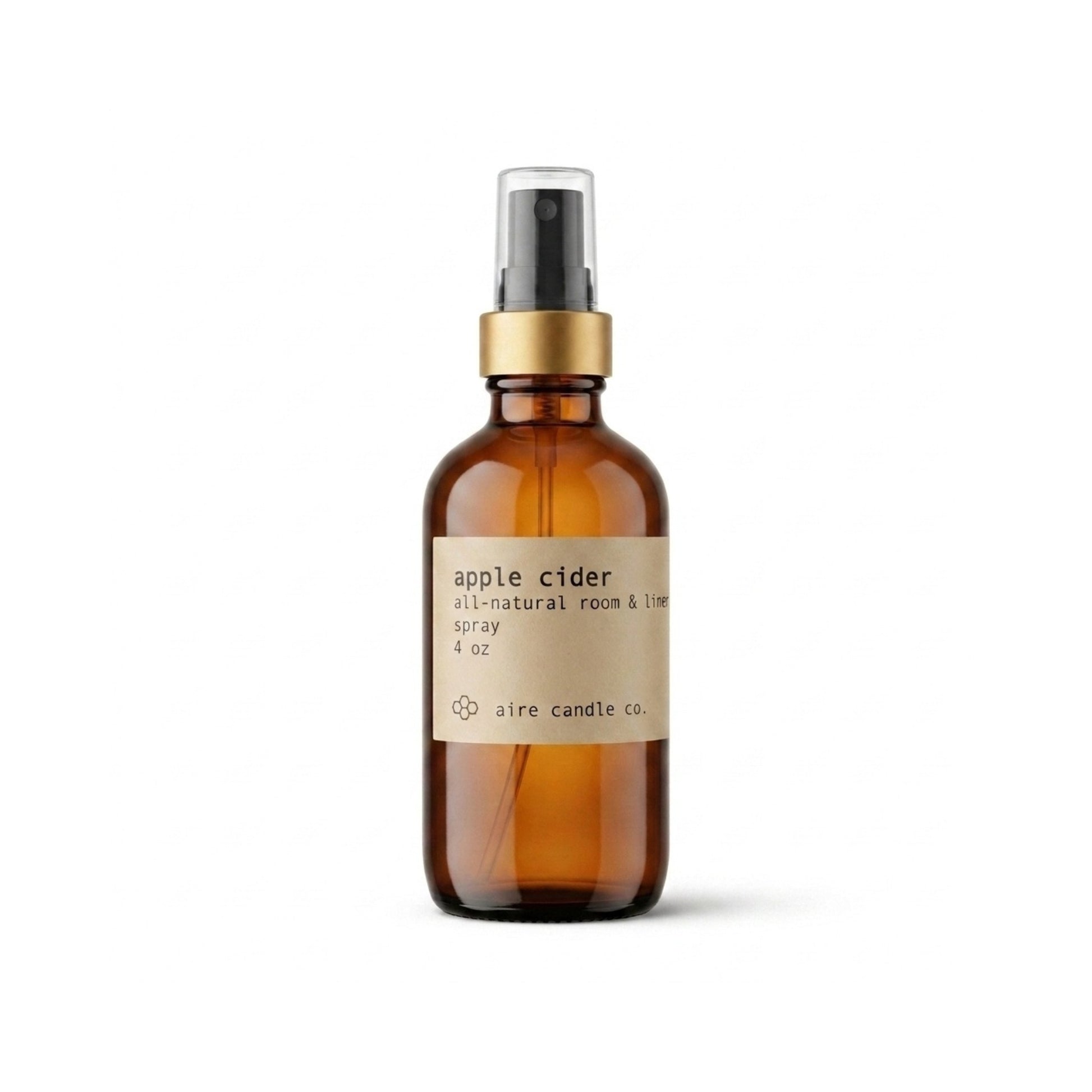 All-natural apple cider scented room spray featuring a black fine mist sprayer, gold rim and amber glass bottle against a white background.