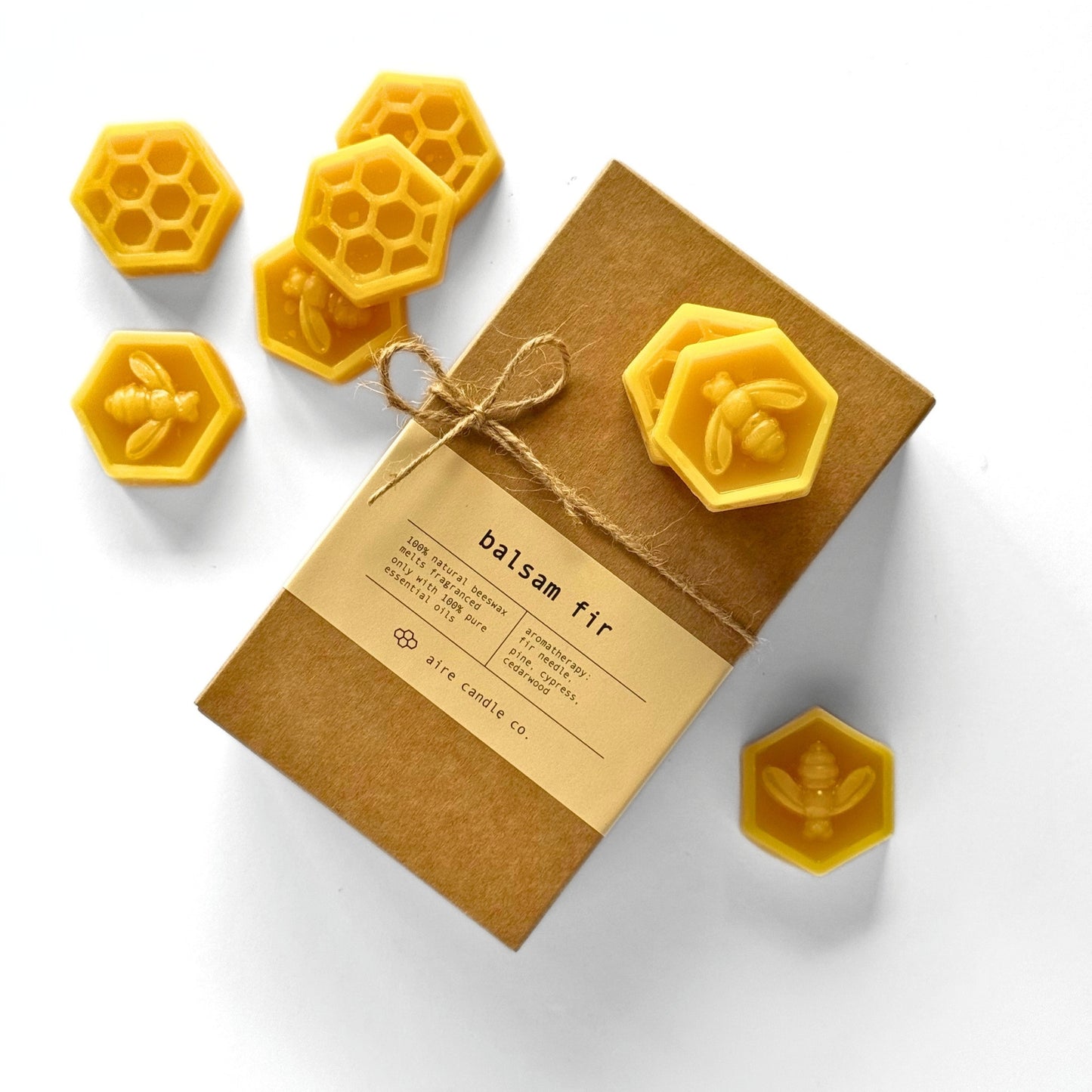 Box of balsam fir candles with honeycomb and bee designs on a white background