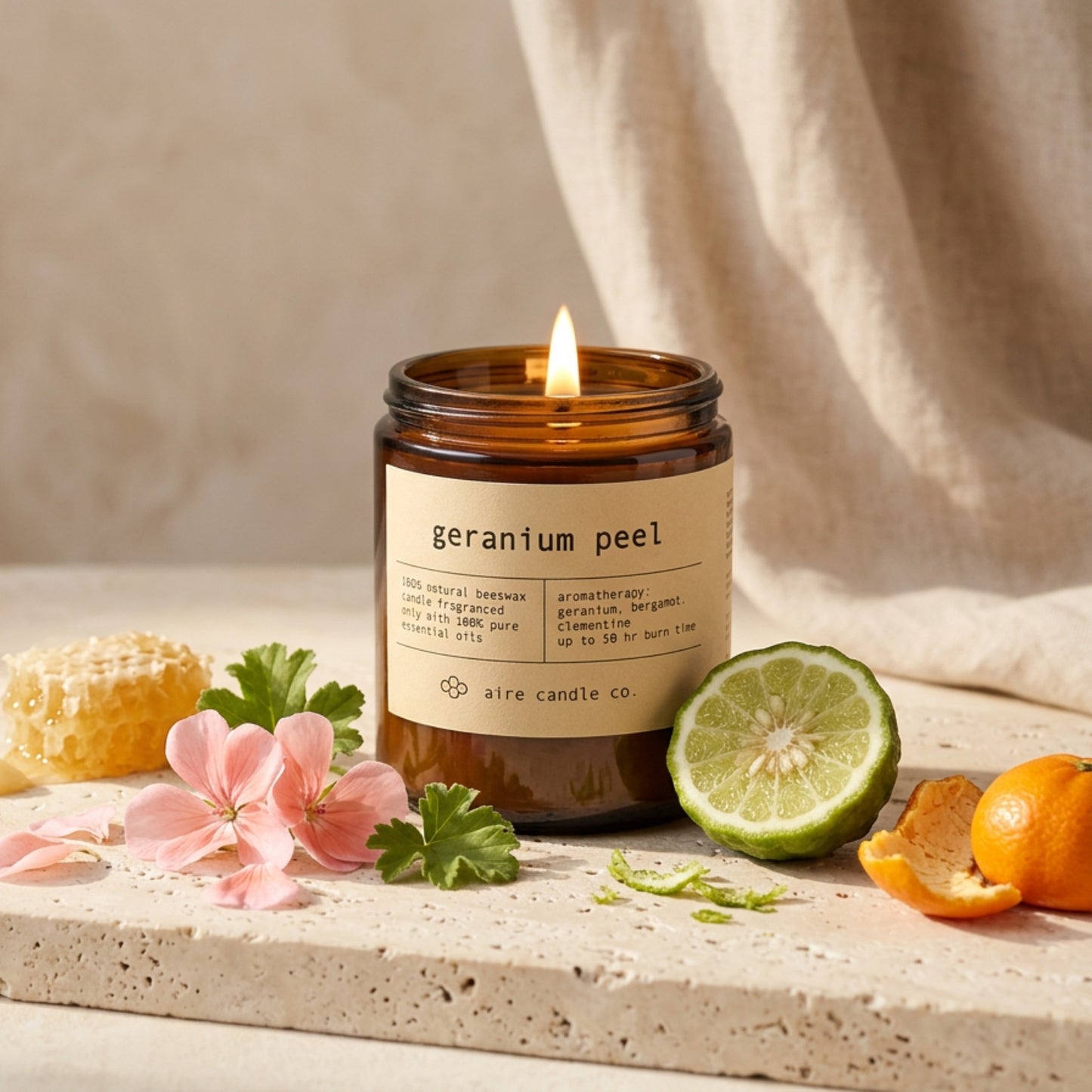 Geranium Peel candle by aire candle co. with natural elements of geranium flowers, bergamot and clementine wedges on a travertine surface.