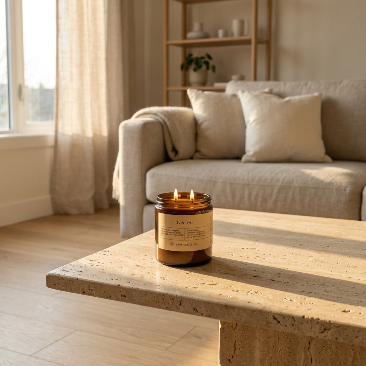 16 oz beeswax candle by aire candle co. labeled 'lav eu' on a travertine coffee table in a cozy living room.