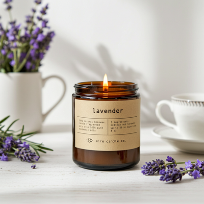 Lavender candle with a label on a table with lavender flowers and a teacup.