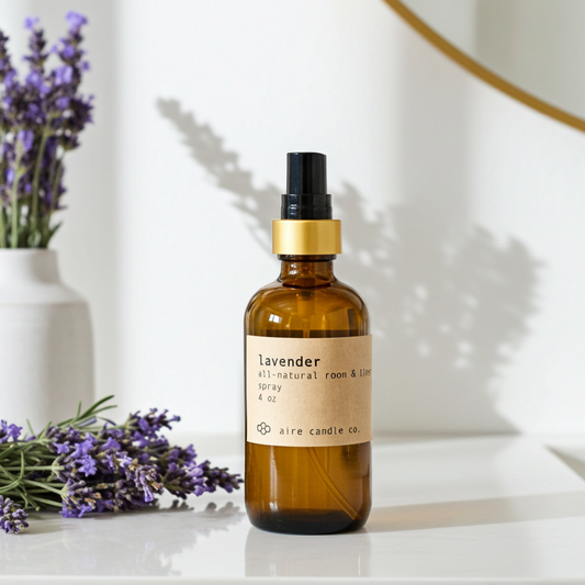 Brown glass bottle with gold cap labeled 'Lavender' on a white surface with lavender flowers.