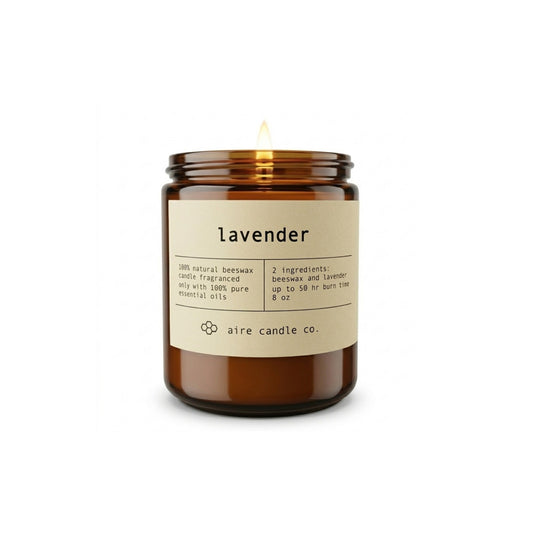 Aire Candle Co. Lavender Beeswax Candle Displayed with an Illuminated Flame Housed in a Protective Amber Glass Jar.