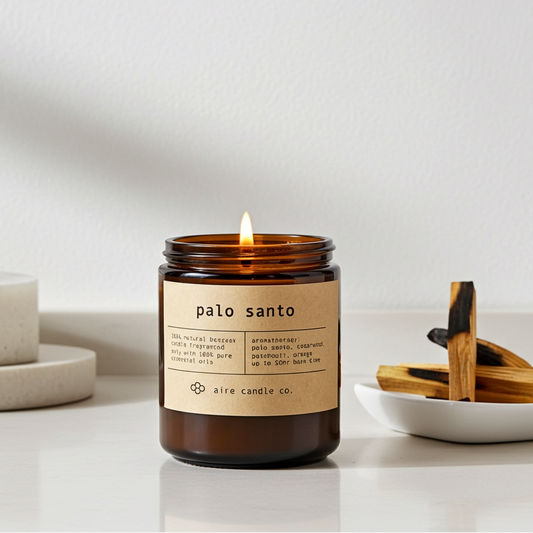 Palo Santo candle with a label on a white surface, surrounded by wooden sticks.