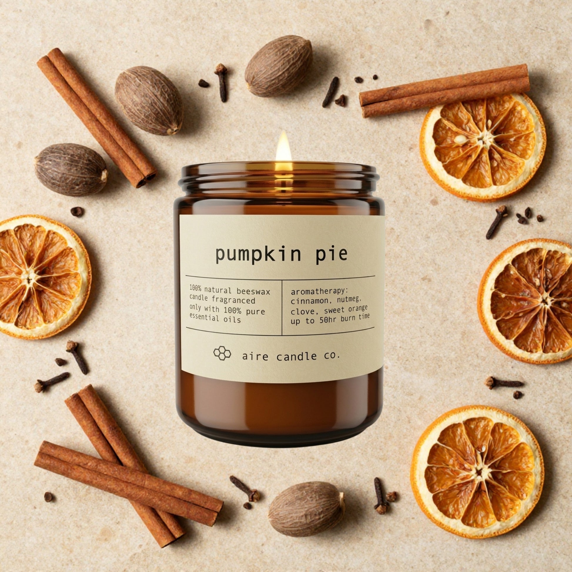 Pumpkin pie scented candle with cinnamon, oranges, and nutmeg on a beige background