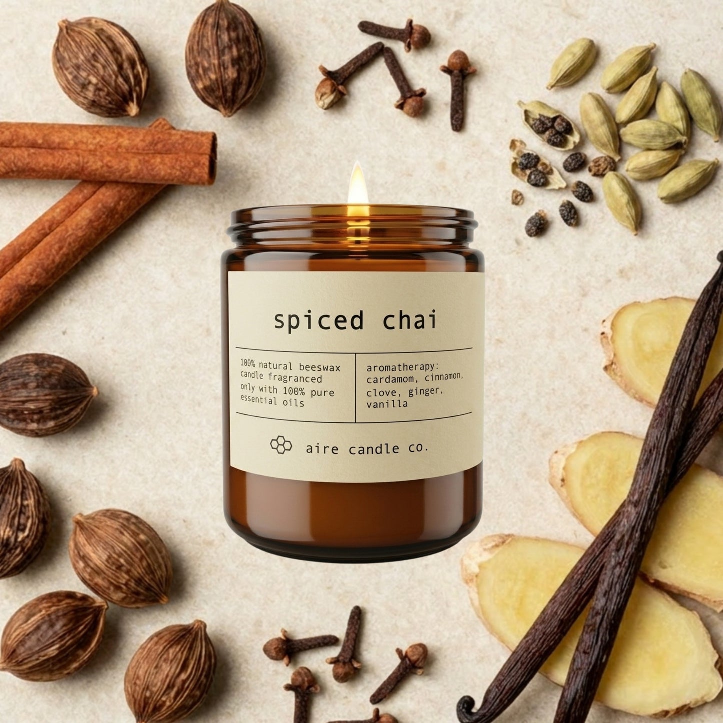 Spiced chai essential oil scented beeswax candle from aire candle co surrounded by cinnamon, ginger, nutmeg, clove, cardamom and vanilla on a light travertine background.