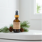 Bottle of spruce & pine toilet bowl spray on a toilet with evergreen scent notes