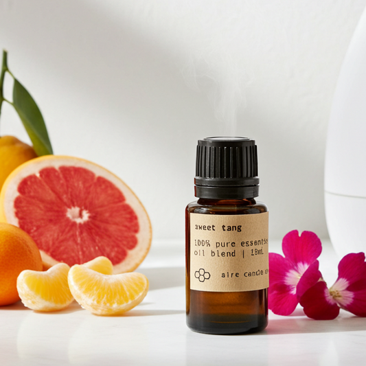Aromatherapy diffuser with essential oil bottle, fruits, and flowers on a white surface