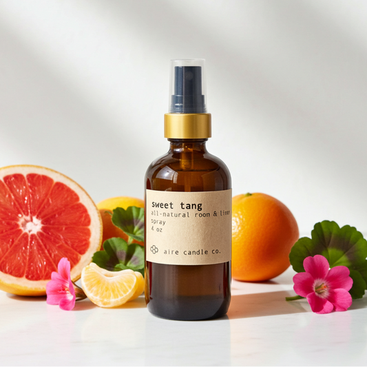 Aromatherapy spray bottle labeled 'sweet tang' with citrus fruits and flowers on a white background