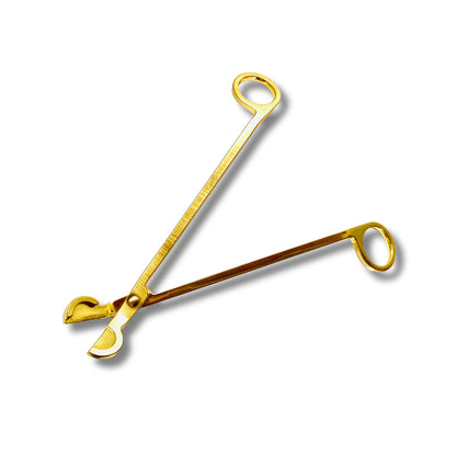 Aire Candle Co. stainless steel wick trimmer in a golden brass finish against a blank white canvas. The wick trimmer is open and ready to cut a candle wick.