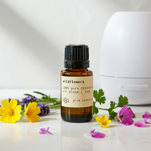 Essential oil bottle labeled 'Wildflowers' with a diffuser and flowers on a light background